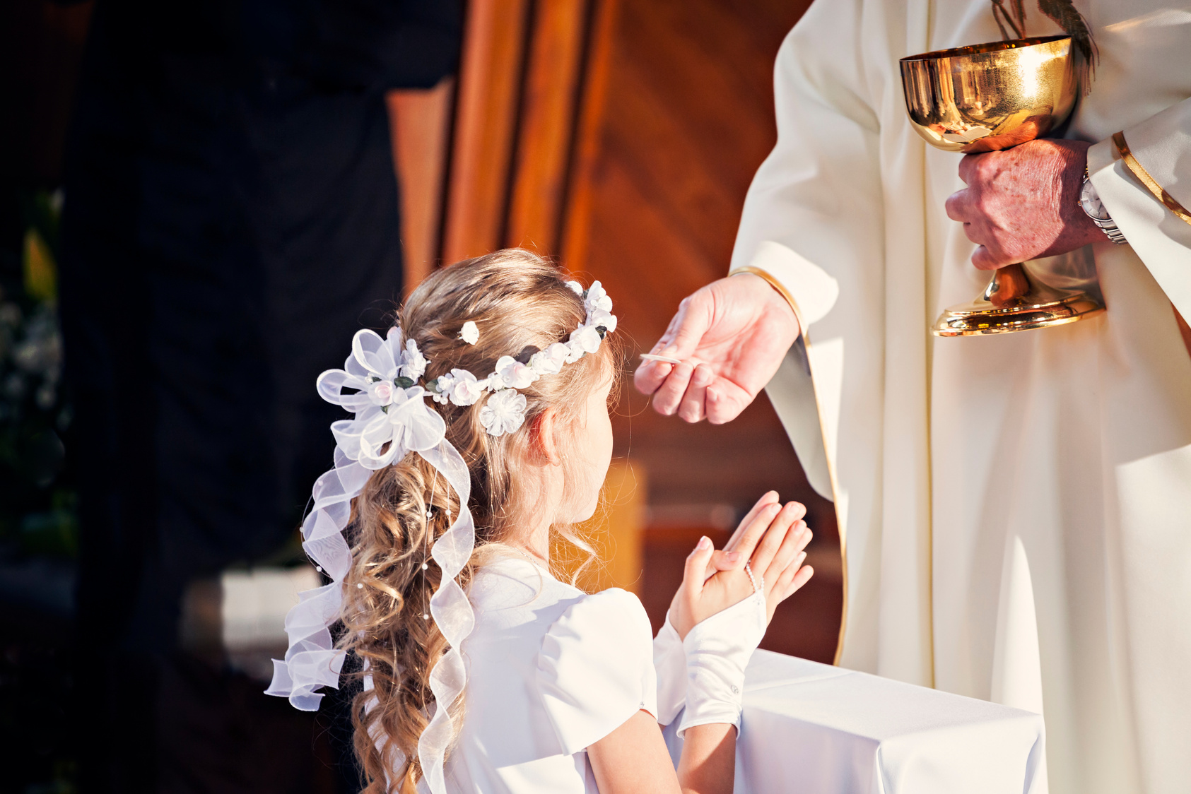 Communion and clergyman. First Holy Communion